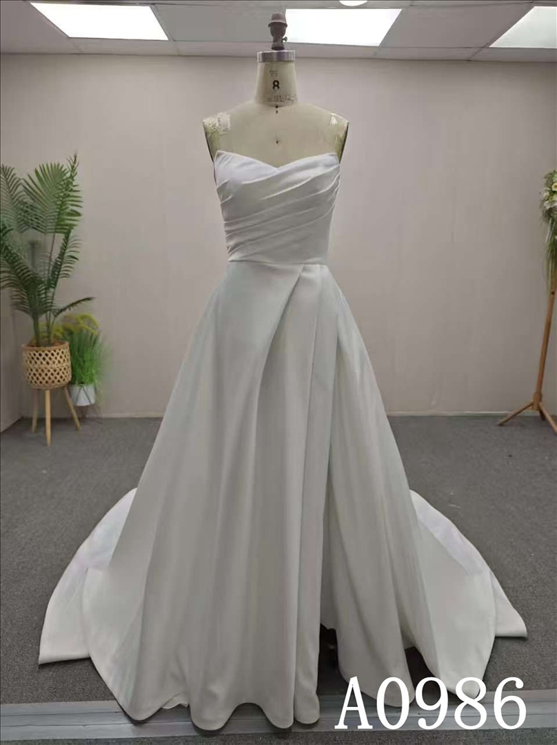 An A-line ivory wedding dress with a simple yet unique design and back zipper and button.