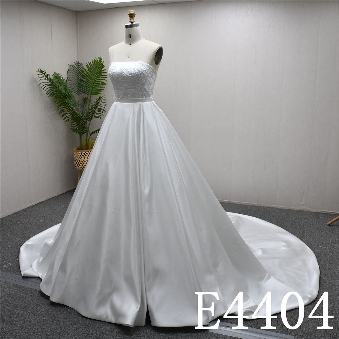 A Simple design Ivory  A-line wedding dress with detachable skirt, adorned with lace.