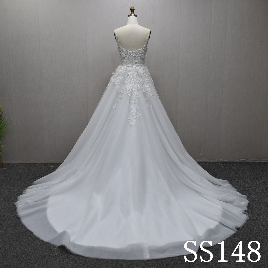 A-line ivory wedding gown with unique design, adorned with three-dimensional flowers and beads