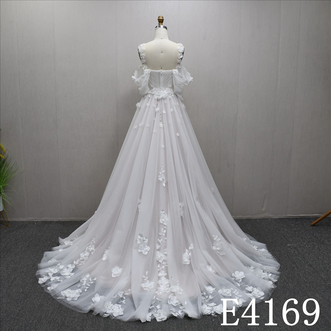 A-line ivory and nude wedding gown with unique design, adorned with Lace flower
