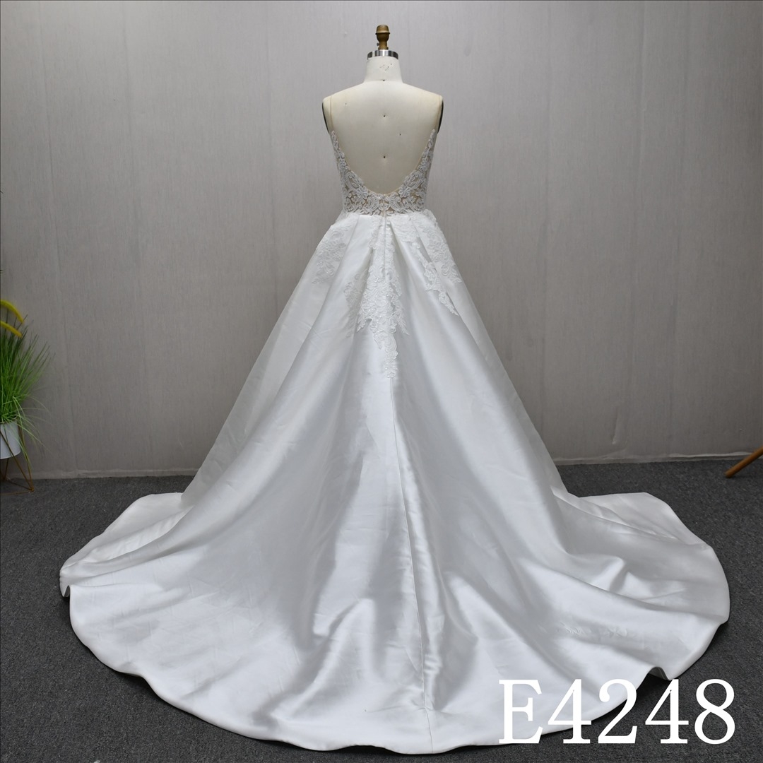 Beautiful and unique A-line lace spaghetti strap wedding dress with a front slit.