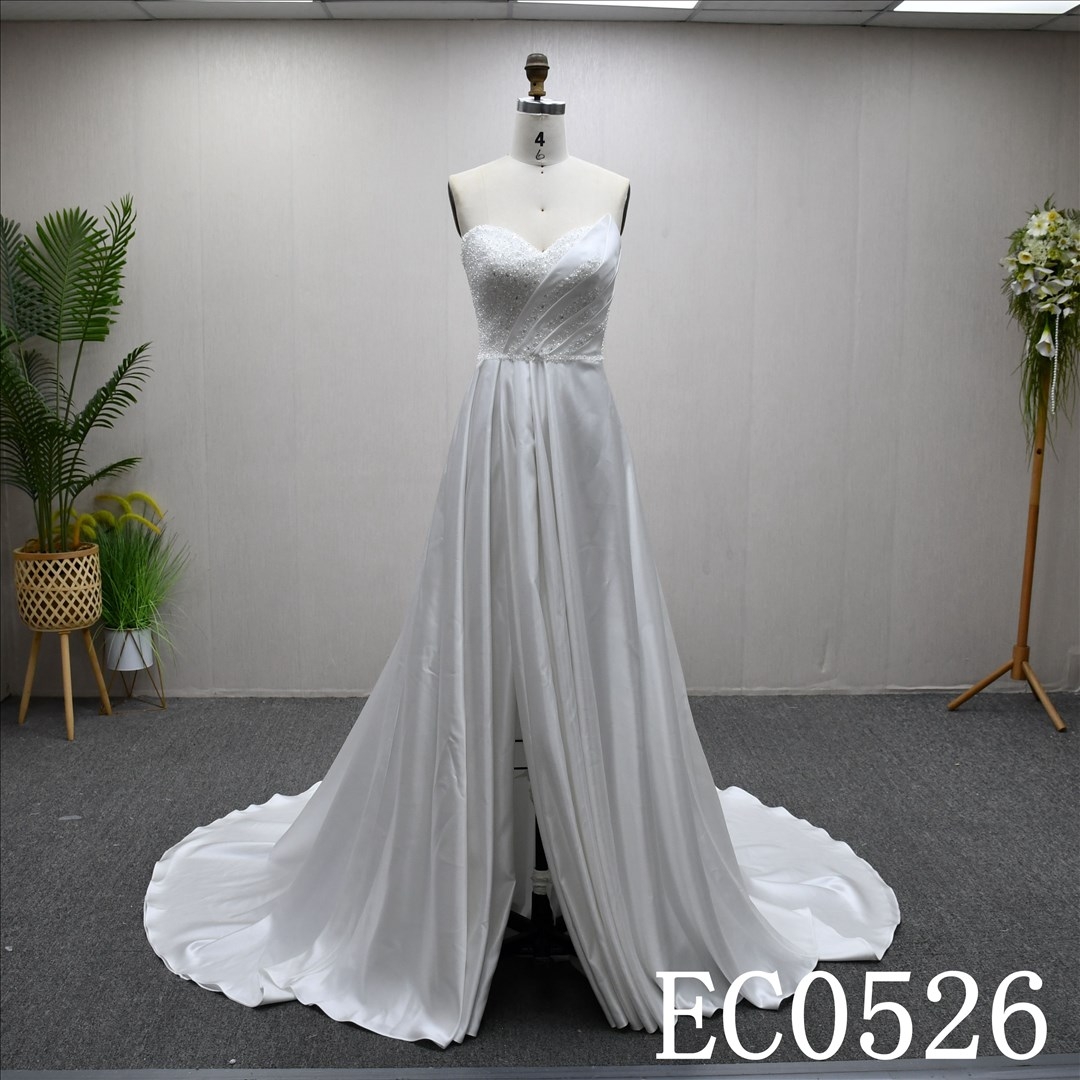 An ivory A-line wedding dress with lace and sequins on the chest and lace up back