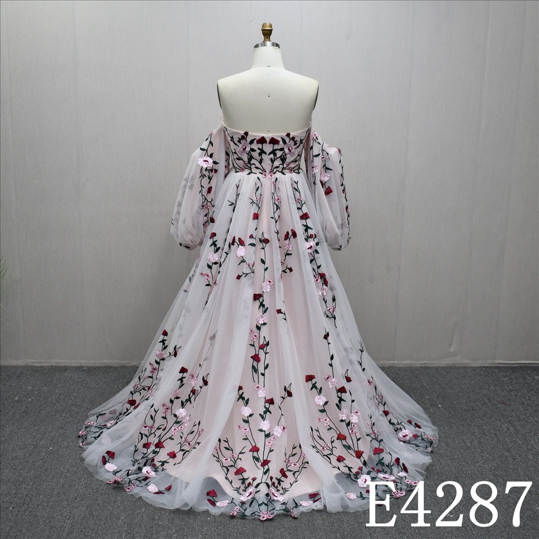 An A-line ivory and blush and colorful lace wedding dress with a simple yet unique design