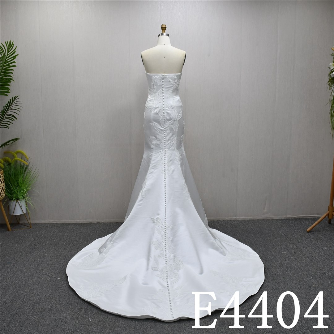A Simple design Ivory  A-line wedding dress with detachable skirt, adorned with lace.