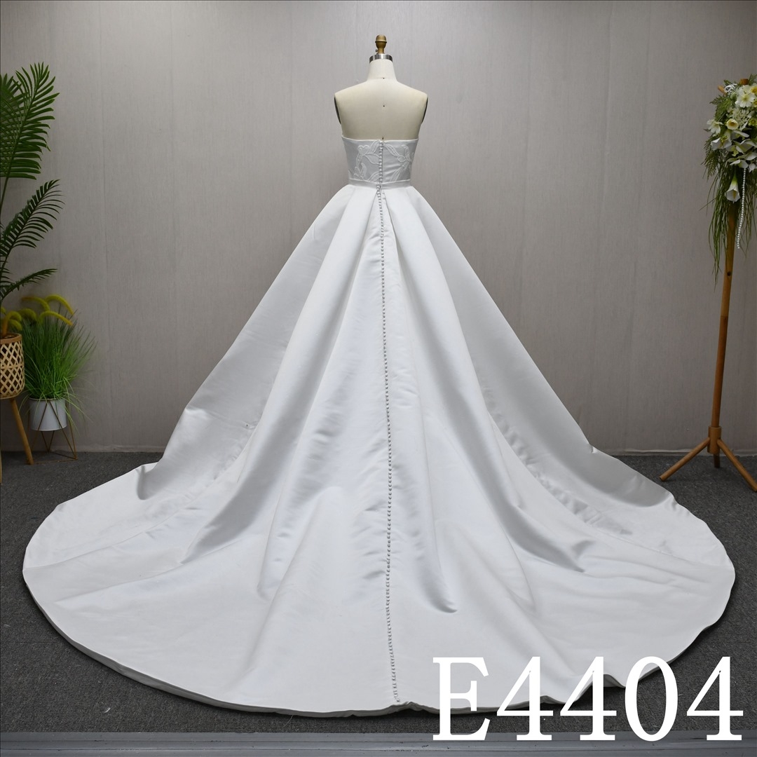 A Simple design Ivory  A-line wedding dress with detachable skirt, adorned with lace.