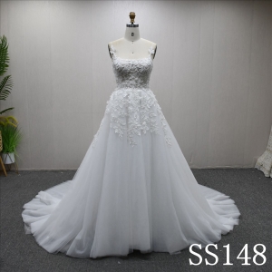 A-line ivory wedding gown with unique design, adorned with three-dimensional flowers and beads