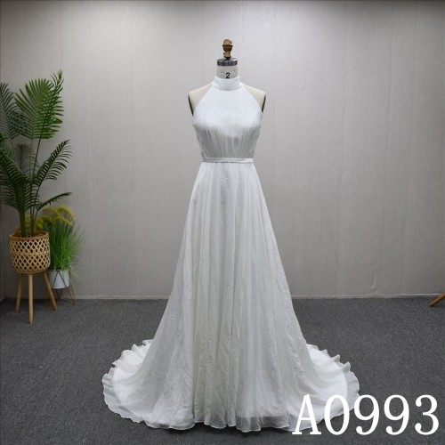 An A-line ivory wedding dress with a simple yet unique design and lace up back.