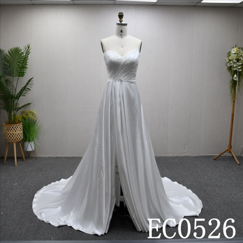 An ivory A-line wedding dress with lace and sequins on the chest and lace up back