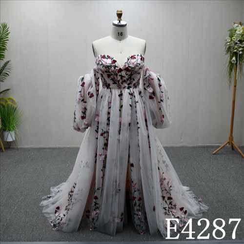 An A-line ivory and blush and colorful lace wedding dress with a simple yet unique design